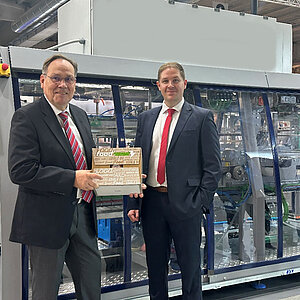 The Thelen team in front of a packaging machine